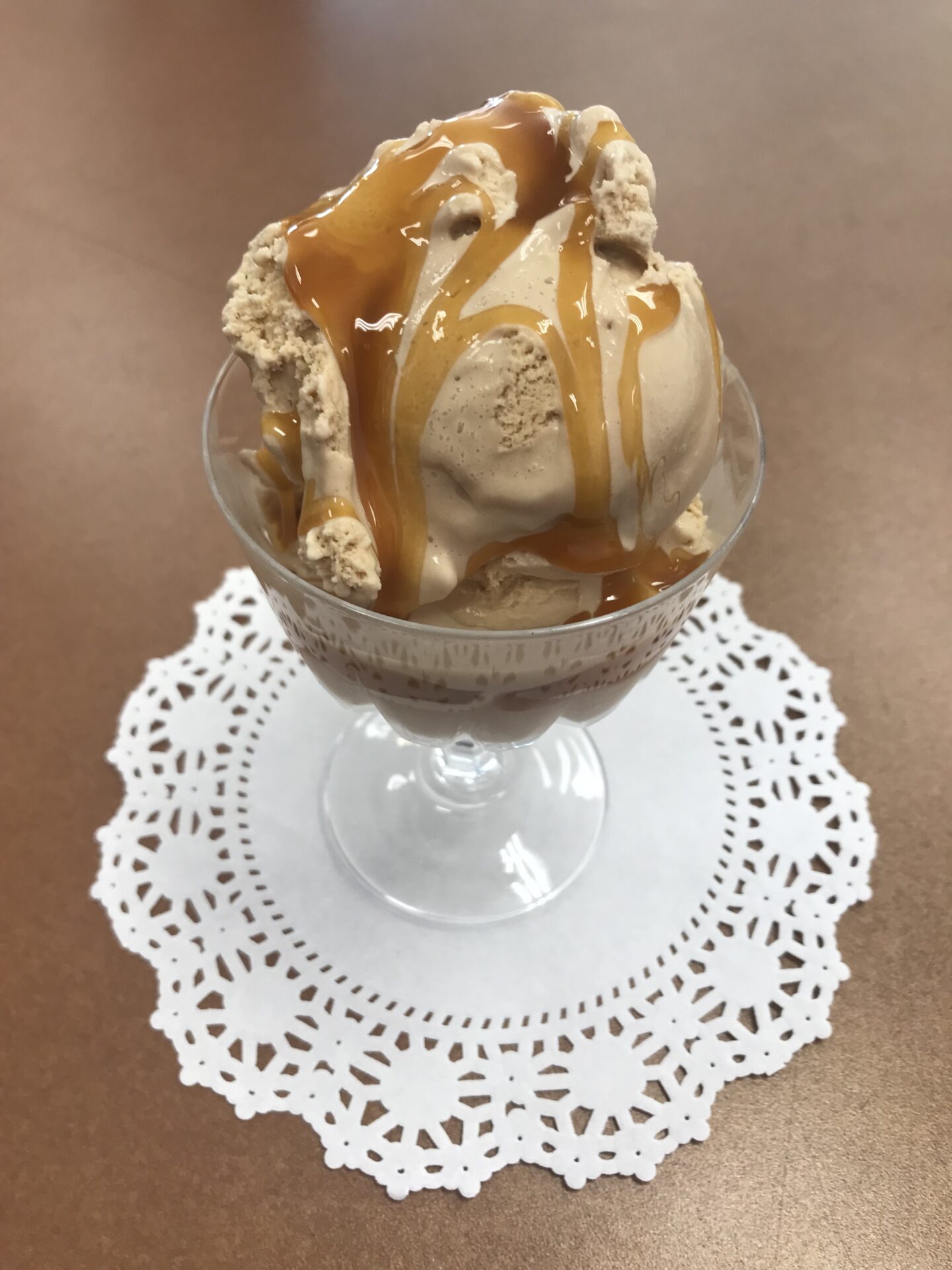 An ice cream drizzled with caramel syrup